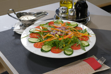 Fresh vegetable salad with mixed greens and a creamy dressing served on a restaurant table setting Healthy eating at its finest