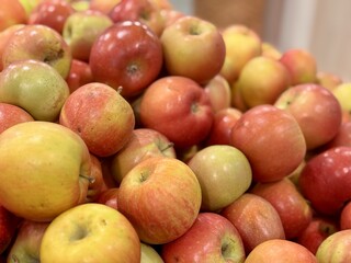 Box filled with fresh natural bio organic red yellow coloured apples placed on counter in local food market. Close-up
