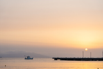 Sunsets over bay delivering a golden glow over calm water