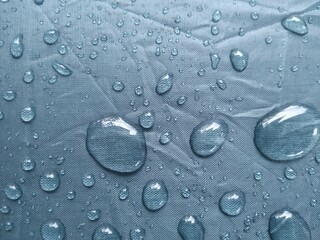 Raindrops wet the army green umbrella.