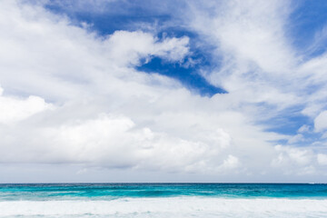 Peaceful ocean waters meet a vibrant blue sky. Mahe, Seychelles