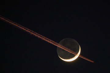Fototapeta premium Ein Passagierflugzeug fliegt vor dem Mond vorbei