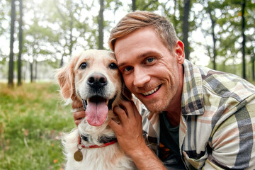 A Happy Man Smiling with His Beloved Dog in a Beautiful Forested Setting Amid Nature