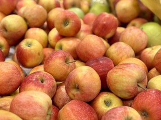 Box filled with fresh natural bio organic red yellow coloured apples placed on counter in local food market. Close-up