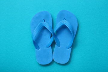 Pair of child's flip-flops on color background