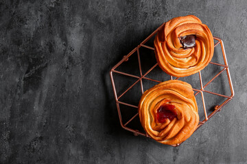 Grid of tasty cruffins with chocolate and jam on black background