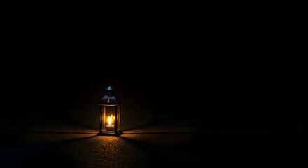 Illuminated Lantern Burning Brightly on Ground in a Dark Background