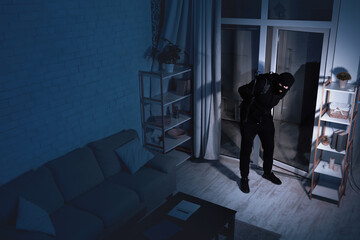 Housebreaking Concept. Intruder sneaking into house at night, holding crowbar, top view from above...