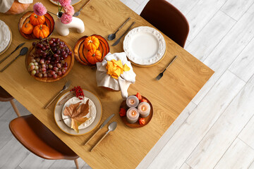 Autumn table setting with pumpkins, grapes and dry leaves