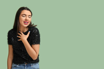 Beautiful young happy woman on green background