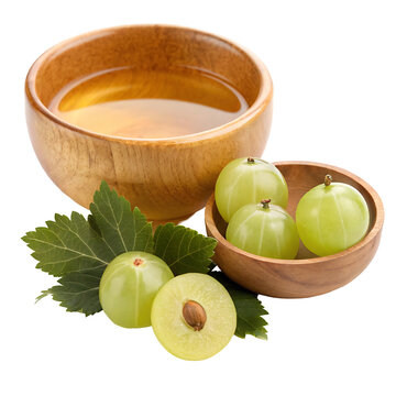 Amla oil in a small wooden bowl with amla and leaves isolated on white background