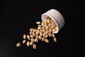 Scattered pistachios isolated on black background