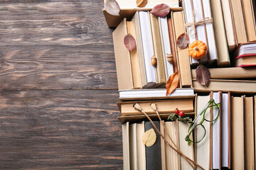 Obraz premium Books with autumn leaves, eyeglasses and acorns on wooden background