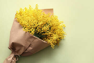 Bouquet of beautiful yellow mimosa flowers on green background
