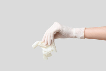 Female hand with used medical glove on grey background