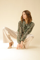 Series of studio photos of young female model wearing beautiful fall outfit, autumn print green...