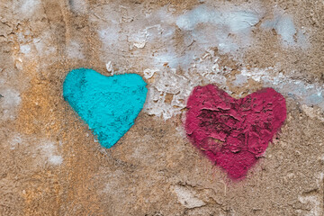 Two textured hearts painted in blue and red on an aged concrete wall. Artistic street graffiti symbolizes love, contrast, urban expression background. Love, graffiti concept