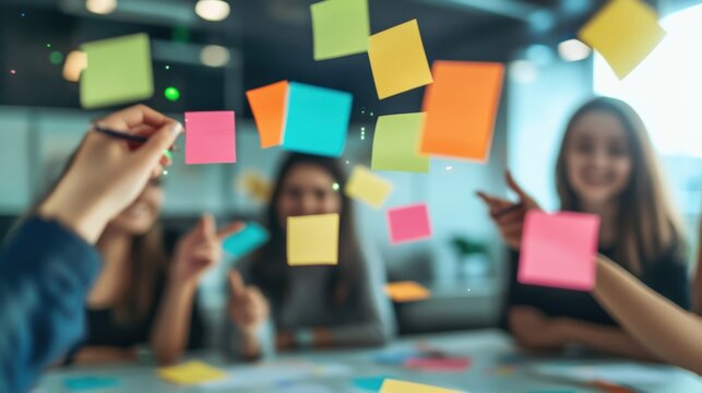 Businesswomen are having a meeting and planning strategy using colorful sticky notes on a glass wall in a modern office, working together on a new project