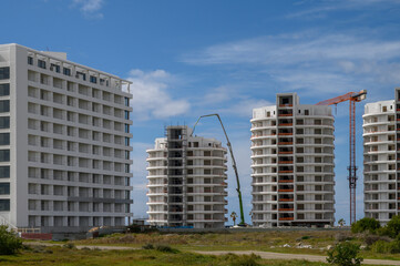 Modern residential buildings under construction in a sunny coastal setting
