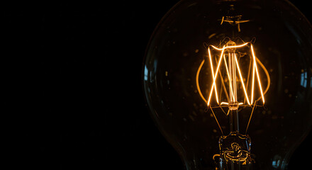 Close-Up of Vintage Filament Light Bulb with Warm Glow and Glass Design on Dark Background