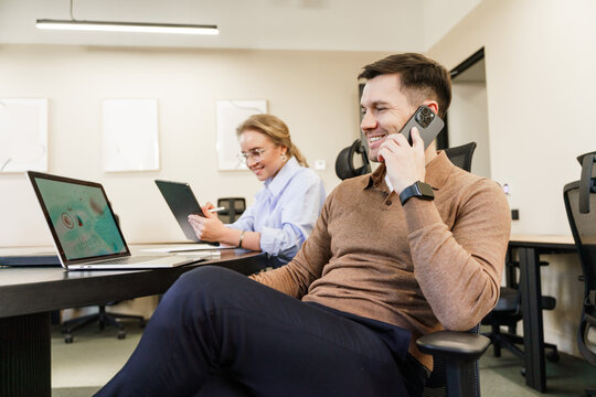 Co-workers engaged in a collaborative work environment with technology at a modern office