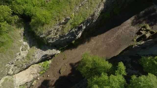 Drone footage of Maltas Canyon, Dagestan, capturing the wide valley flanked by towering moss-covered mountains, creating a cinematic landscape.
