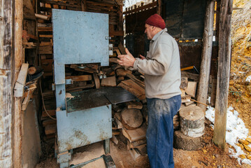 Carpenter Cutting Wood with a Bandsaw in a Rustic Workshop