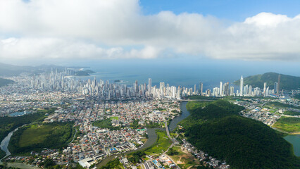 Drone shot of Balneário Camboriú, showcasing the bustling BR-101 highway, the city’s skyline, and the expansive Atlantic Ocean beyond.