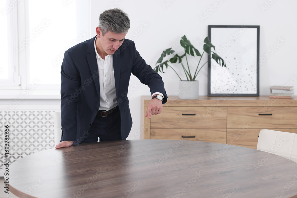 Poster man pointing at something on desk in office. space for text