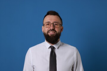 Handsome bearded man in formal outfit on blue background