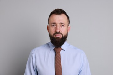 Handsome bearded man in formal outfit on grey background