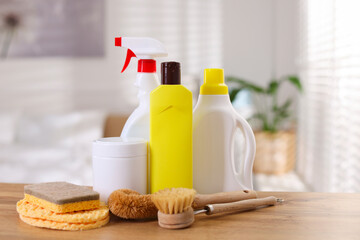 Different cleaning products and supplies on wooden table indoors