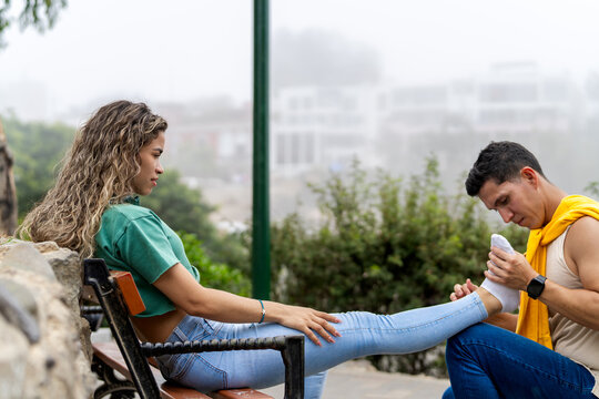 Man taking care of injured girlfriend with sprained foot