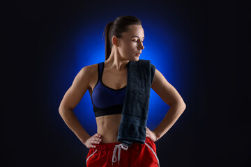 Sporty woman with terry towel on dark blue background