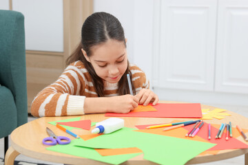 Girl drawing card at table indoors. Art and craft