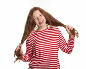 Beautiful teenage girl with freckles winking and showing her tongue on white background