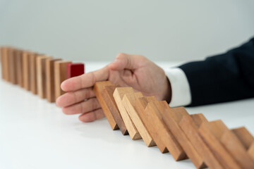 insurance with hands protect domino. Businessman hands stop dominoes falling in business crisis. business risk control and planning and strategies to run prevent insurance businesses.