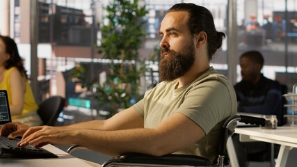 System administrator with disability in inclusive workspace training machine learning models. IT...