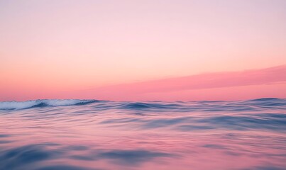 Obraz premium A serene soft pink sunrise illuminating an endless ocean, evoking tranquility and beauty in nature.