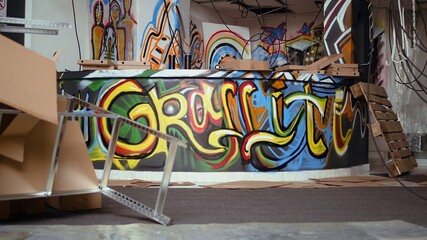 Empty vandalized property with graffiti paintings on walls, concept of alternative lifestyle. City slums ghetto location used as crime base of operations by hooligans doing street art, panning shot