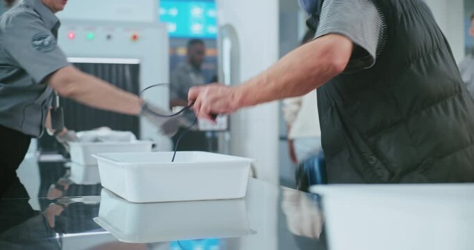 Security Checkpoint in Airport: Diverse People, Tourists Putting Personal Items and Baggage for X-ray Scanning, Then Walking Through Metal Detector Scanner. TSA Worker Controlling Screening Procedure.
