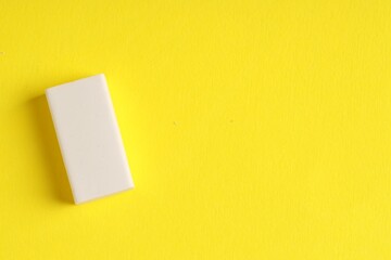 One eraser on yellow background, top view. Space for text