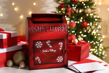 Santa Claus mailbox, letters, gift boxes and Christmas decor on white table indoors