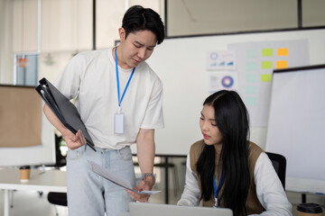 Fototapeta premium Young professionals analyzing financial documents together in a bright office