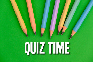the words Quiz Time beside mini alarm clock on a plain background. the concept of answering quizzes...