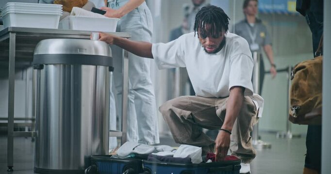 Airport Security Checkpoint: African American Man Removes Liquids from Suitcase, Throws in Trash Can. Crowd of Diverse People, Passengers Going Through TSA Screening Procedures before Boarding Flight.