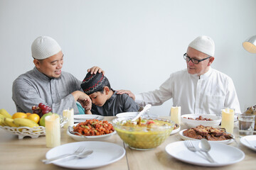 Young Boy Apologizing To His Father At Dining Room On Celebrating Eid Mubarak