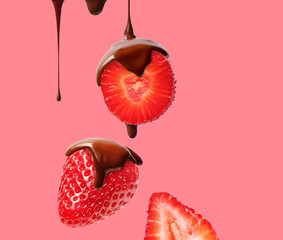 Creative layout made of bar of dark  chocolate and strawberry on the pink background. Flat lay. Food concept.  Melted chocolate on the strawberry on the pink.