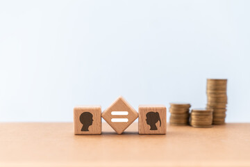 For gender pay equality concept. man and woman icon on wooden cube block with blurred stack of...