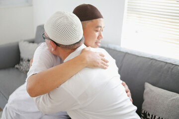 Muslim Family Forgiving Each Other. Grandfather Embrace His Son On Eid Al Fitr